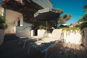 two chairs and an umbrella on a wooden deck at Van der Valk Hotel Le Catalogne Saint Aygulf in Saint-Aygulf +88 photos