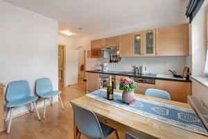 a kitchen with a wooden table and blue chairs at Haus Lowe Appartement 1 Stock Nr 3 in Filzmoos