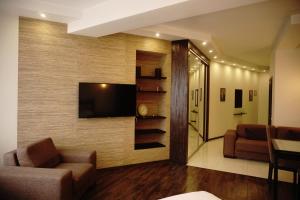 sala de estar con TV de pantalla plana en la pared en Doba In Ua Most-Sity Apartments, en Dnipro