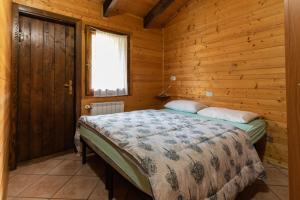 ein Schlafzimmer mit einem Bett in einer Holzhütte in der Unterkunft Parco Del Sangro in Castel di Sangro
