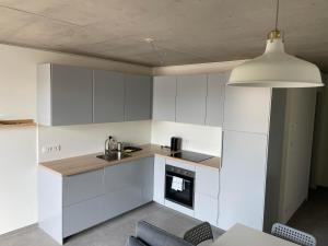 a kitchen with white cabinets and a sink at Int. Appartment Kolbermoor in Kolbermoor