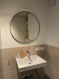 a bathroom with a white sink and a mirror at Int. Appartment Kolbermoor in Kolbermoor