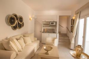 a white living room with a couch and a table at Santorini Secret Suites & Spa, Small Luxury Hotels of the World in Oia