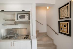 a kitchen with a sink and a microwave at Santorini Secret Suites & Spa, Small Luxury Hotels of the World in Oia