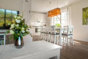 a kitchen and dining room with a table and chairs at Ferien-im-Duenenhaus Lasse in Glowe