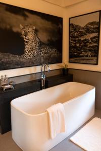 a bath tub in a bathroom with a picture of a leopard at SUJÁN JAWAI - Relais & Chateaux in Pāli