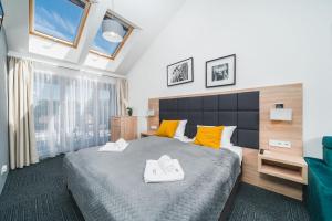 sypialnia z dużym łóżkiem z żółtymi poduszkami w obiekcie Aron Residence - by Upstairs w Krakowie