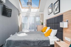 sypialnia z dużym łóżkiem z żółtymi poduszkami w obiekcie Aron Residence - by Upstairs w Krakowie
