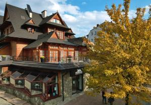 a large wooden house with a gambrel roof at Pokoje Krupówki 13 - Hotel Sabała in Zakopane