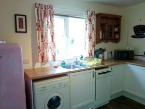 a kitchen with a sink and a washing machine at The Wee Anchor in Arbroath