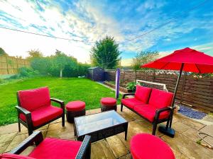a patio with two chairs and a table and an umbrella at A LUXURY DETACHED FIVE STAR 4 bed Victorian home with HOT TUB!! in Panteg