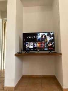 TV de pantalla plana en un estante de la pared en Departamento en pleno centro, a metros de todo ! en San Rafael