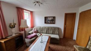 a living room with a couch and a table at Bauernstübchen in Below