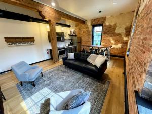 a living room with a black leather couch and chairs at Gamble Mill in Bellefonte