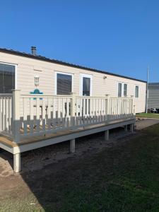 a house with a wooden deck in front of it at Great Deals at The Grange, Ingoldmells in Skegness
