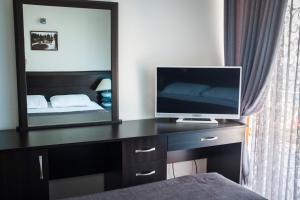 a bedroom with a desk with a television and a mirror at Hotel Neptun Kvariati in Kvariati
