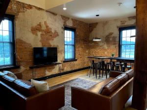 a living room with leather couches and a bar at Gamble Mill in Bellefonte