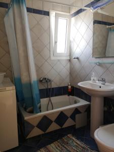 een badkamer met een bad en een wastafel bij Nostos - Psili Ammos Apartments in Psilí Ámmos