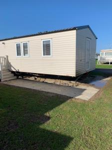 a small white house with a porch and a yard at Great Deals at The Grange, Ingoldmells in Skegness