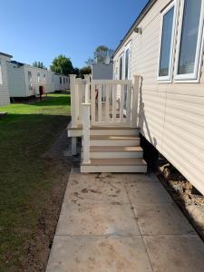 a house with a wooden staircase next to a house at Great Deals at The Grange, Ingoldmells in Skegness