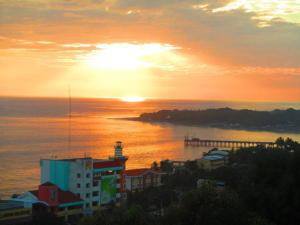 een zonsondergang boven een waterlichaam met een vuurtoren bij Casita Escondida - Incredible View in La Libertad