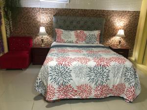 a bedroom with a large bed and a red chair at Hotel Cana Palma Zona Colonial in Santo Domingo