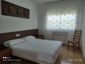 een slaapkamer met een bed en een houten stoel bij Villa Galicia in Lloret de Mar +60 foto's