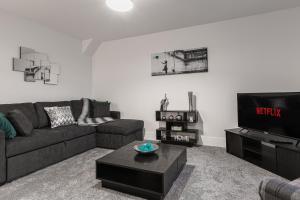 a living room with a couch and a tv at Tannery Place - 3 Bedrooms Parking Wi-Fi Garden in Freckleton