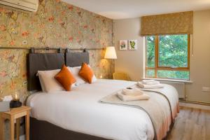 a bedroom with a large white bed with orange pillows at The Royal Foundation of St Katharine in London