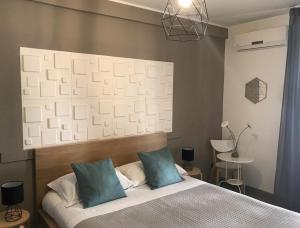 - une chambre avec un lit et 2 oreillers bleus dans l'établissement B&B Stesicoro InHabit - GuestHouse City Center, à Catane