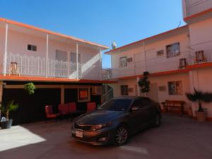 un coche aparcado en un aparcamiento frente a un edificio en Consul Suites, en Ciudad Juárez