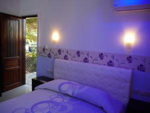 a purple bedroom with a bed with a purple headboard at Blue Bay Beach Hotel in Koinyra