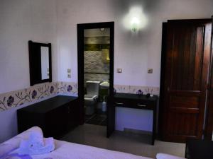 a bathroom with a sink and a toilet and a mirror at Blue Bay Beach Hotel in Koinyra