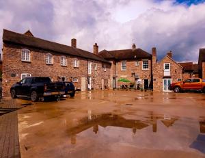 a parking lot in front of a brick building at The Little Pheasant Apartment Ironbridge Gorge in Broseley