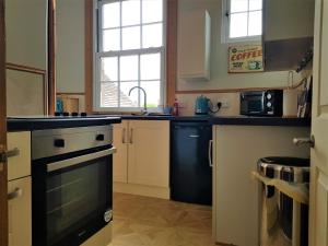 a kitchen with a stove and a sink at The Little Pheasant Apartment Ironbridge Gorge in Broseley