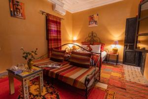 ein Schlafzimmer mit einem Bett und einem Tisch in einem Zimmer in der Unterkunft Riad Losra in Marrakesch