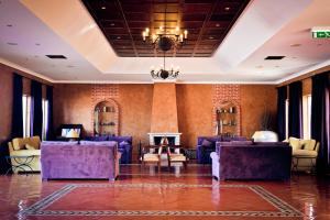 a lobby with purple furniture and a fireplace at Vila Gale Albacora in Tavira
