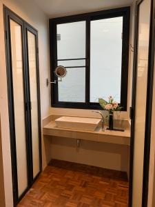 une salle de bain avec un lavabo et une fenêtre dans l'établissement Baannaisoi2 Mini Hotel, à Chiang Mai