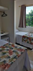 two beds in a room with a window at Pousada e Restaurante Império do Marisco in Maragogi +53 photos