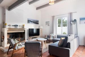 a living room with a couch and a fireplace at TETHYS VILLA AVEC PISCINE ET PROCHE DE LA MER in Sainte-Marie-de-Ré