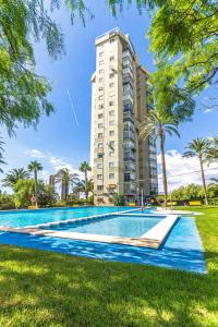 a swimming pool in front of a tall building at Amazing Benidorm Views 2BR Flat - Pool - Parking in Benidorm