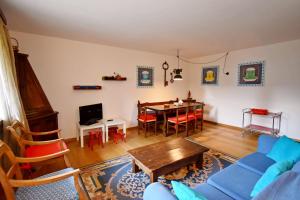 a living room with a blue couch and a table at Appartamento al Passo in Madonna di Campiglio