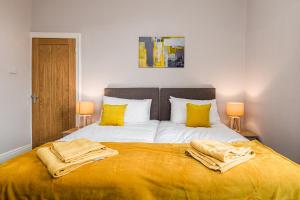 sypialnia z dużym łóżkiem z żółtymi poduszkami w obiekcie Carnarvon House - Wi-Fi & Parking Contractors w mieście Preston