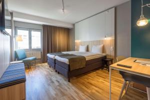 a hotel room with a bed and a desk at Scandic Kista in Stockholm