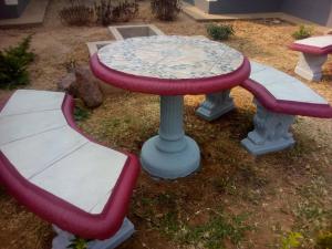 einen Tisch und zwei Bänke in einem Hof in der Unterkunft Ramatie Guest Palace in Kasane