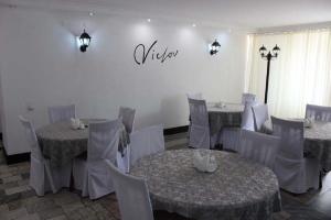 a dining room with tables and chairs and a sign on the wall at Victoria Hotel in Aktau