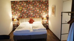 a bedroom with a bed with a floral wall at Ferrum Ferrum in Valkenburg