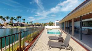 a balcony with chairs and a swimming pool at Waterfront Tip Lot Treasure w/ Southern Sunshine in Henry Key