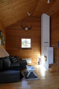 ein Wohnzimmer mit einem schwarzen Sofa und einem Tisch in der Unterkunft Metsorinne 3A sarvipöllö in Kotila
