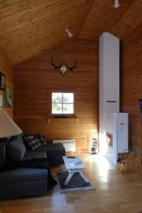 a living room with a black couch and a table at Metsorinne 3A sarvipöllö in Kotila